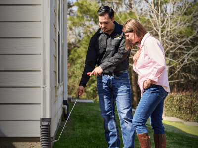 Wildlife specialist conducting property inspection with homeowner